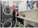 Efficient laundry room with a stacked washer/dryer and ample storage shelves at 19836 Hidden Glen Dr, Land O Lakes, FL 34638