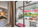Relaxing outdoor patio with red umbrellas, leading to a sparkling pool and green backyard at 19836 Hidden Glen Dr, Land O Lakes, FL 34638