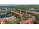 Beautiful aerial view showcasing condos adjacent to tennis courts, a lake, and lush green spaces, offering resort-style living at 2400 Feather Sound Dr # 1235, Clearwater, FL 33762