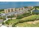 Aerial view of condos next to a golf course, with water views in the distance at 2617 Cove Cay Dr # 206, Clearwater, FL 33760