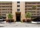 View of the building entrance showing covered parking and mature landscaping at 2617 Cove Cay Dr # 206, Clearwater, FL 33760