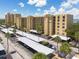 Low-angle view of the exterior elevation of the condo building highlighting a parking lot and surrounding trees at 2617 Cove Cay Dr # 206, Clearwater, FL 33760