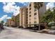 Multi-story condo building with covered parking and palm trees against a sunny, partly cloudy sky at 2617 Cove Cay Dr # 206, Clearwater, FL 33760