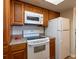 Kitchen view featuring appliances and warm wood cabinets at 2617 Cove Cay Dr # 206, Clearwater, FL 33760