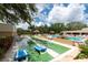 Community shuffleboard and pool area with tiki umbrellas and lush tropical landscaping at 2617 Cove Cay Dr # 206, Clearwater, FL 33760