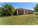 A well-maintained backyard with a screened lanai, lush lawn, mature trees, and tropical landscaping at 2637 Yukon Cliff Dr, Ruskin, FL 33570