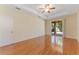 Well-lit bedroom with hardwood floors, a ceiling fan, tray ceilings, and a sliding glass door at 2637 Yukon Cliff Dr, Ruskin, FL 33570