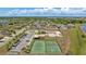 Wide aerial view of the community clubhouse, pool, and sports courts surrounded by palm trees at 2637 Yukon Cliff Dr, Ruskin, FL 33570