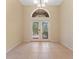 Elegant dining room featuring decorative glass french doors, and neutral tile flooring at 2637 Yukon Cliff Dr, Ruskin, FL 33570