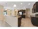 Open kitchen with breakfast bar, dark cabinetry, stainless steel appliances and tile floors at 2637 Yukon Cliff Dr, Ruskin, FL 33570