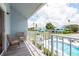 Balcony view overlooks a sparkling community pool, inviting you to unwind amidst charming architecture and lush palm trees at 2643 St Josephs W Dr, Dunedin, FL 34698