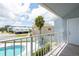 Inviting balcony view overlooking the pool and lush tropical landscape; coastal living at its finest at 2643 St Josephs W Dr, Dunedin, FL 34698