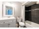 Stylish bathroom featuring dark tiled shower with decorative stripe, a modern vanity and updated fixtures at 2643 St Josephs W Dr, Dunedin, FL 34698
