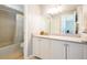 Well-lit bathroom with granite counters, generous cabinetry, and a tub-shower combo offers a blend of style and functionality at 2643 St Josephs W Dr, Dunedin, FL 34698