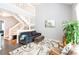 Bright living room featuring a comfortable sofa and modern staircase with white railing at 2643 St Josephs W Dr, Dunedin, FL 34698
