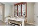 Cozy dining area with a white dining table and woven bench seating, decorated with elegant mirrors at 31326 Ancient Sage Rd, Wesley Chapel, FL 33545