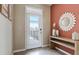 Bright foyer with a decorative sunflower mirror, console table, and view to the outside at 31326 Ancient Sage Rd, Wesley Chapel, FL 33545