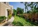 A beautifully landscaped backyard with green grass, a wooden fence, and a variety of plants at 3174 Eagles Landing W Cir # 58, Clearwater, FL 33761