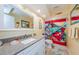 Bright bathroom features a granite countertop, white vanity, and colorful fish-themed shower curtain at 3174 Eagles Landing W Cir # 58, Clearwater, FL 33761