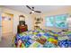 Bright bedroom with colorful quilt, ceiling fan, and natural light from the large window at 3174 Eagles Landing W Cir # 58, Clearwater, FL 33761