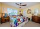 Bedroom featuring a colorful patchwork quilt, a ceiling fan, and two side tables at 3174 Eagles Landing W Cir # 58, Clearwater, FL 33761