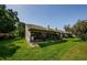 Back of home, highlighting a screened lanai overlooking the manicured lawn and mature trees at 3174 Eagles Landing W Cir # 58, Clearwater, FL 33761
