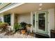 Inviting covered front porch with decorative door, plants, and brick pavers at 3174 Eagles Landing W Cir # 58, Clearwater, FL 33761