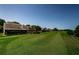 Scenic view of well-maintained golf course and lush landscaping surrounding residential buildings, with clear blue sky at 3174 Eagles Landing W Cir # 58, Clearwater, FL 33761
