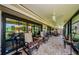 Covered and screened lanai featuring multiple seating areas and serene outdoor views at 3174 Eagles Landing W Cir # 58, Clearwater, FL 33761