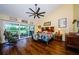 Main bedroom with wood floors, ceiling fan, slider access to patio, and colorful bedding at 3174 Eagles Landing W Cir # 58, Clearwater, FL 33761