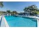 Community pool surrounded by lounge chairs and greenery, offering a refreshing and relaxing retreat at 3174 Eagles Landing W Cir # 58, Clearwater, FL 33761