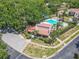 Aerial view shows community clubhouse and pool, surrounded by lush landscaping and trees at 3505 Tarpon Woods Blvd # N405, Palm Harbor, FL 34685