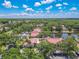 Aerial view showcases the community's serene setting with lush trees and a peaceful pond at 3505 Tarpon Woods Blvd # N405, Palm Harbor, FL 34685