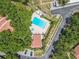 Overhead view of community pool, hot tub, and amenity center surrounded by mature trees and convenient parking at 3505 Tarpon Woods Blvd # N405, Palm Harbor, FL 34685