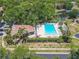 Aerial shot of a community pool and community building with mature trees and pond view at 3505 Tarpon Woods Blvd # N405, Palm Harbor, FL 34685