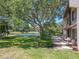 Backyard view features a private patio with seating, lush green grass, and a serene lake at 3505 Tarpon Woods Blvd # N405, Palm Harbor, FL 34685
