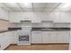 A bright kitchen with white appliances, cabinets, and dark granite countertops at 3505 Tarpon Woods Blvd # N405, Palm Harbor, FL 34685