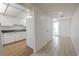 An entryway from tiled hall to kitchen with white appliances and cabinets at 3505 Tarpon Woods Blvd # N405, Palm Harbor, FL 34685