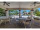 Covered patio with seating overlooking the community pool and beautifully landscaped surroundings at 3505 Tarpon Woods Blvd # N405, Palm Harbor, FL 34685
