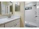 Bright bathroom features a white vanity with quartz countertop and walk-in shower with new shower head at 3604 Arlington Oaks Ct, Tampa, FL 33618
