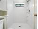 Bright white tiled walk-in shower with window and rainfall shower head at 3604 Arlington Oaks Ct, Tampa, FL 33618