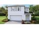 Two-story home featuring a two-car garage, neutral color scheme, and well-maintained landscaping at 36123 Sunflower Hill Dr, Zephyrhills, FL 33541