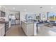 Open kitchen featuring stainless appliances, a kitchen island with seating, and an open view to the living room at 36123 Sunflower Hill Dr, Zephyrhills, FL 33541