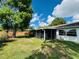 Backyard showing screened-in patio, expansive lawn, and privacy fencing, perfect for outdoor activities at 3845 Edgemont Dr, New Port Richey, FL 34652