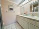 Bathroom with double sinks, tiled floors, and a modern framed mirror and shower stall at 3845 Edgemont Dr, New Port Richey, FL 34652