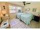 Bright bedroom featuring two twin beds, a ceiling fan, and large windows for natural light at 3845 Edgemont Dr, New Port Richey, FL 34652