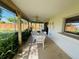 View of a screened patio with table and chairs, with plants and greenery to enhance the appeal at 3845 Edgemont Dr, New Port Richey, FL 34652