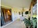 View of an outdoor patio with dining set, ceiling fan, and access to kitchen through sliding glass doors at 3845 Edgemont Dr, New Port Richey, FL 34652