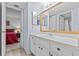 Bathroom features white cabinetry, framed mirror, and an open view to the bedroom at 39650 Us Highway 19 N # 553, Tarpon Springs, FL 34689