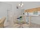Cozy dining area with glass table, seating for four, and modern chandelier at 39650 Us Highway 19 N # 553, Tarpon Springs, FL 34689